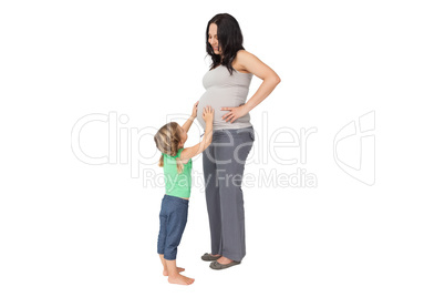 Little girl touching her mothers baby bump