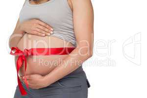 Pregnant woman with a red bow around her bump