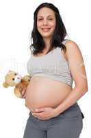 Pregnant woman holding a teddy smiling at camera