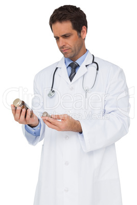 Concentrating doctor reading label on medicine jar
