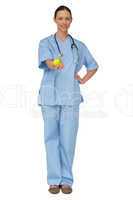 Smiling nurse in scrubs holding green apple