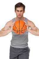 Fit man holding basketball about to throw to camera