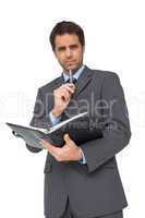 Handsome thinking businessman holding his diary