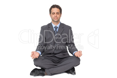 Calm businessman meditating in lotus pose