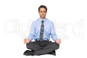 Zen businessman meditating in lotus pose with eyes closed