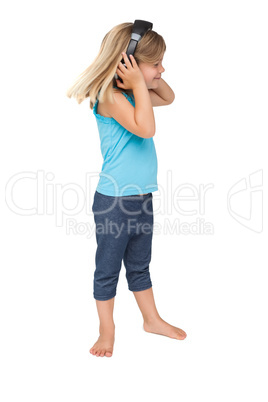 Cute little girl listening to music and dancing