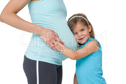 Cute little girl listening to her mothers belly