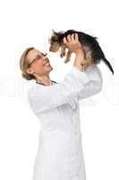 Vet lifting up yorkshire terrier puppy and smiling