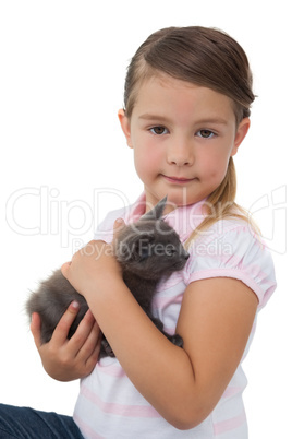 Cute girl holding grey kitten smiling at camera