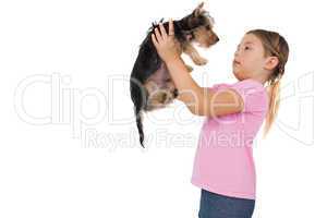 Little girl lifting up yorkshire terrier puppy