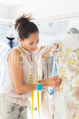 Beautiful fashion designer working on dress at the studio