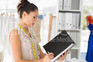 Female fashion designer looking at folder