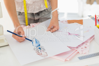 Mid section of a fashion designer working on her designs