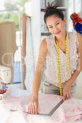 Smiling female fashion designer working on fabrics