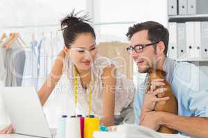 Fashion designers using laptop in studio