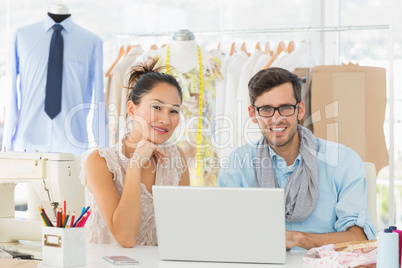 Fashion designers using laptop in studio