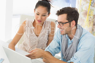 Fashion designers using laptop in studio