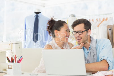 Fashion designers using laptop in studio