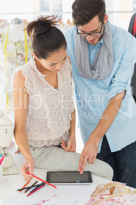 Fashion designers using digital tablet in studio