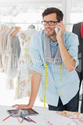 Smiling male fashion designer using mobile phone