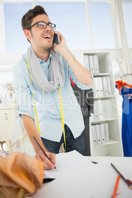 Fashion designer working on his designs while on call