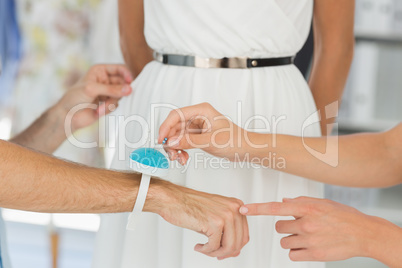 Closeup of designers adjusting dress on model