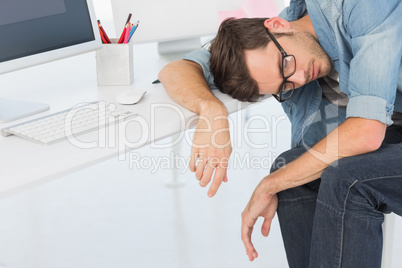 Young casual man sleeping in front of computer