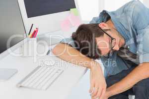 Young casual man sleeping in front of computer