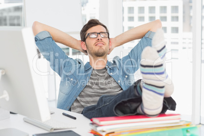 Casual young man with legs on desk in office