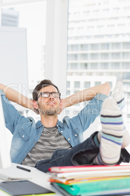 Casual young man with legs on desk in office