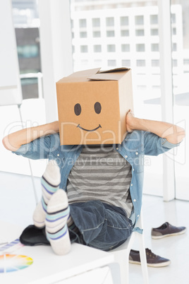 Casual man with happy smiley box over face at office