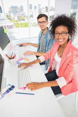 Smiling casual young couple working on computers