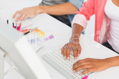 Mid section of a casual couple working on computers