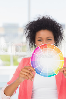 Beautiful young woman holding color wheel