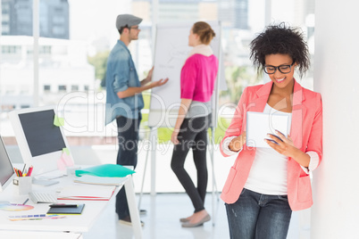 Artist using digital tablet with colleagues in at office