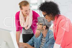 Smiling artists working on computer at office