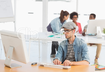 Male artist using computer with colleagues in at office
