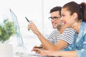 Happy young couple working on computer in an office