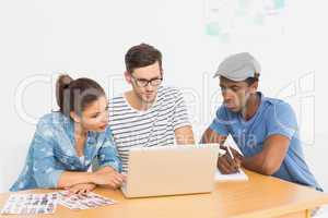 Three concentrated young artists working on laptop