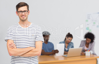 Casual male artist with colleagues in background at office