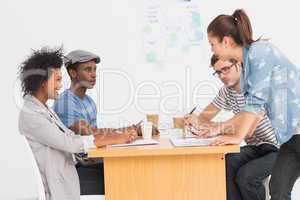 Group of artists in discussion at desk at office