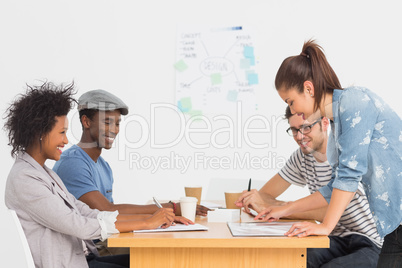 Group of artists in discussion at desk at office