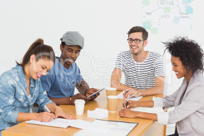 Group of happy artists in discussion at desk