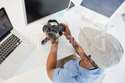 Photo editor looking at digital camera in office