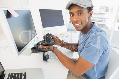 Male photo editor with digital camera in office