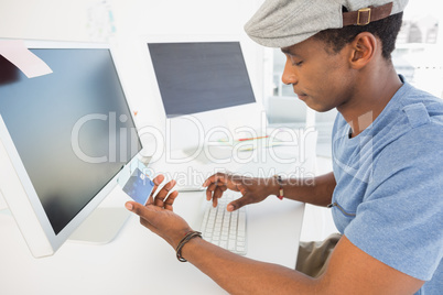 Casual young man doing online shopping in office