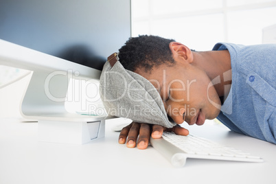 Male artist with head resting on keyboard in the office