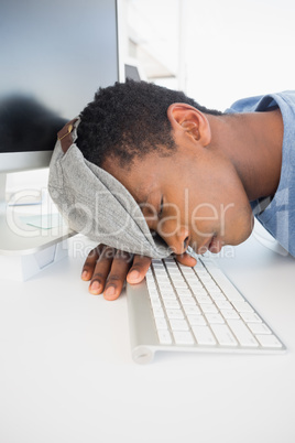 Male artist with head resting on keyboard in office