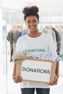 Smiling young woman with clothes donation