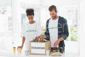 Smiling young couple with donation box